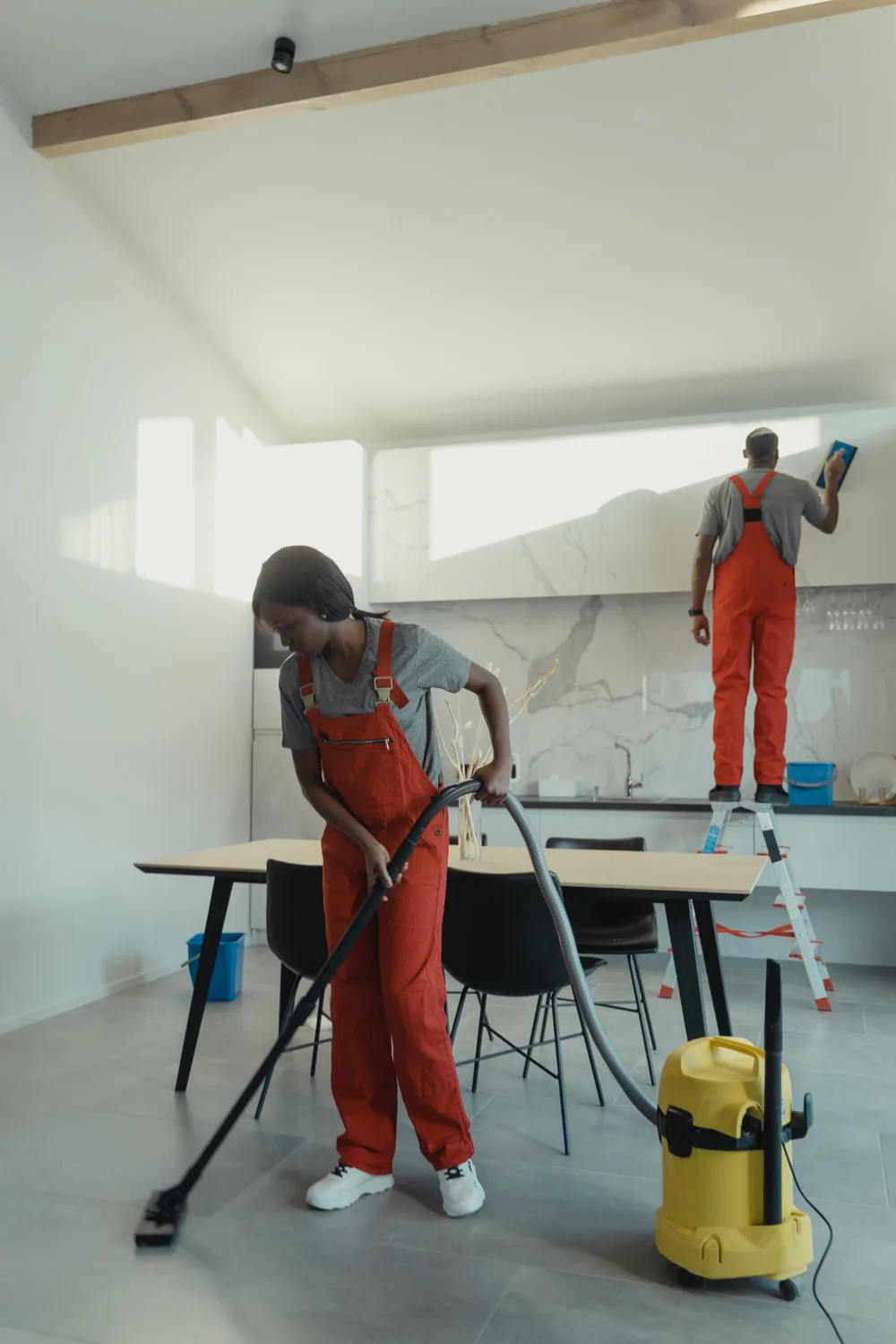 Dadou Elite Cleaning team vacuuming and detailing a bright modern home
